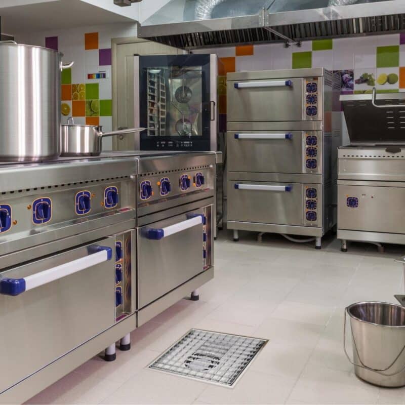 Impressie van een professionele keuken, voorzien van een RVS afvoergoot met een maasrooster.