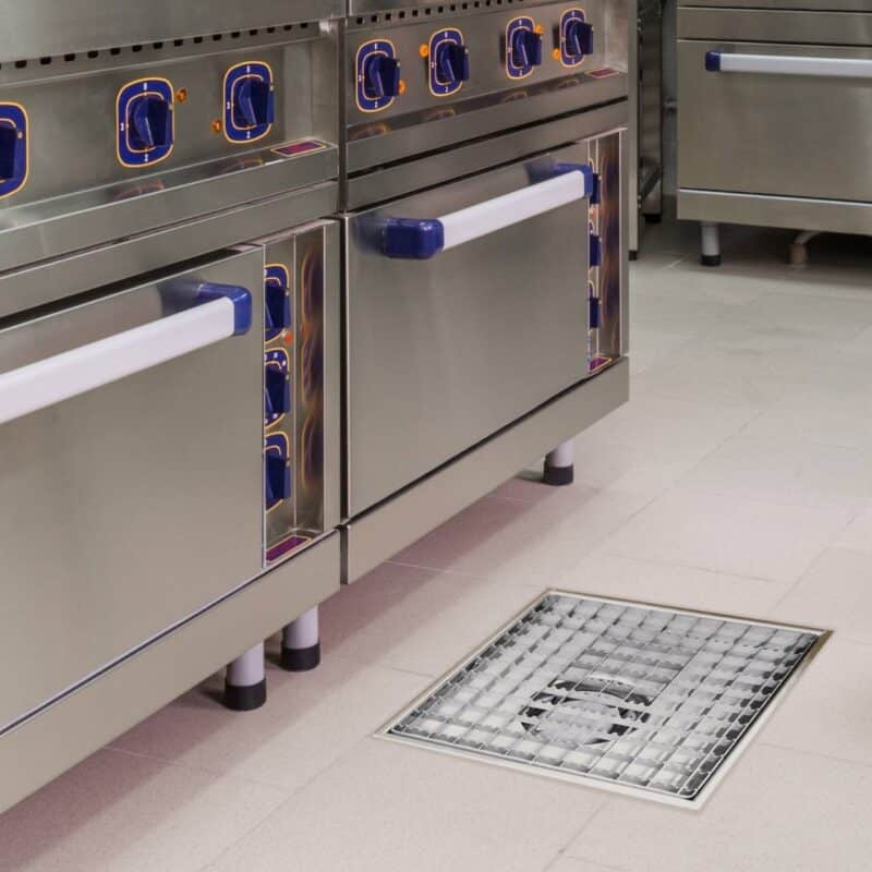 Impressie van een professionele keuken, voorzien van een RVS afvoergoot met een maasrooster.